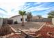 Large backyard with gravel, red mulch, and a palm tree at 13652 W Fargo Dr, Surprise, AZ 85374