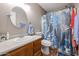 Updated bathroom with wood vanity and cactus shower curtain at 13652 W Fargo Dr, Surprise, AZ 85374