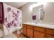 Clean bathroom with wood vanity and floral shower curtain at 13652 W Fargo Dr, Surprise, AZ 85374