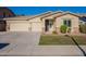 Tan house with two-car garage and landscaped yard at 18522 W Mountain View Rd, Waddell, AZ 85355