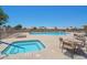 Community pool and spa with lounge chairs and tables under a clear sky at 20058 N 109Th Dr, Sun City, AZ 85373
