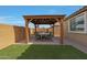 Covered patio with seating area, fire pit, and artificial turf at 22446 E Russet Rd, Queen Creek, AZ 85142