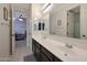 Bright bathroom with double sinks, dark vanity, and access to a bedroom at 22446 E Russet Rd, Queen Creek, AZ 85142