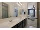 Bathroom with double sinks, dark vanity, and a view into a bedroom at 22446 E Russet Rd, Queen Creek, AZ 85142