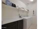 Bright laundry room with washer, dryer, shelving, and cabinets at 22446 E Russet Rd, Queen Creek, AZ 85142