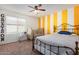 Bright bedroom with crib, large bed, and yellow-striped wall at 4102 S 186Th Ave, Goodyear, AZ 85338