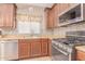 Kitchen features stainless steel appliances and wood cabinetry at 44023 W Stonecreek Rd, Maricopa, AZ 85139