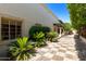 Inviting patio with checkered tile flooring, lush landscaping, and access to the home at 6701 N Scottsdale Rd # 20, Scottsdale, AZ 85250