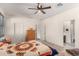 Spacious bedroom with a queen-size bed, ceiling fan, and access to a private bathroom at 1526 E Saint Catherine Ave, Phoenix, AZ 85042