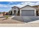 Single-story home with gray garage door and landscaped front yard at 15547 W Magnolia St, Goodyear, AZ 85338