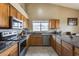 Kitchen with wood cabinets, granite countertops, and stainless steel appliances at 15547 W Magnolia St, Goodyear, AZ 85338