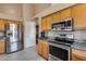 Modern kitchen with stainless steel appliances and wood cabinets at 15547 W Magnolia St, Goodyear, AZ 85338