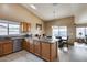 Kitchen with an island, wood cabinets, and stainless steel appliances at 15547 W Magnolia St, Goodyear, AZ 85338