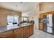 Open kitchen features granite countertops, stainless steel appliances, and an island at 15547 W Magnolia St, Goodyear, AZ 85338