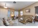Bright living room with tiled floors, comfortable seating, and large windows at 15547 W Magnolia St, Goodyear, AZ 85338