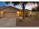 Inviting desert home exterior with a two-car garage and landscaped front yard at 20566 N Lemon Drop Dr, Maricopa, AZ 85138