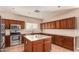 Kitchen with wood cabinets, granite island, and stainless steel appliances at 41229 W Laramie Rd, Maricopa, AZ 85138