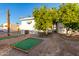 Landscaped backyard with two putting greens and citrus trees at 44 S Hawes Rd # A15, Mesa, AZ 85208