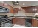 Modern kitchen with dark wood cabinets, granite countertops, and black appliances at 114 W Adams St # 506, Phoenix, AZ 85003