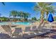 Relaxing community pool with lounge chairs and palm trees at 20521 N Lemon Drop Dr, Maricopa, AZ 85138