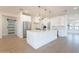 Modern kitchen with white cabinets, large island, and wood floors at 3877 S Veronica Ln, Gold Canyon, AZ 85118