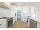Modern kitchen with white cabinets, stainless steel appliances and wood range hood at 3877 S Veronica Ln, Gold Canyon, AZ 85118