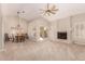 Living room with vaulted ceiling, fireplace, and sliding door to patio at 6653 E Sugarloaf St, Mesa, AZ 85215