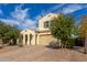 Two-story house with tan exterior, arched entryway, and a paved driveway at 20142 W Sherman St, Buckeye, AZ 85326