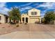 Two-story house with tan exterior, arched entry, and a brick driveway at 20142 W Sherman St, Buckeye, AZ 85326