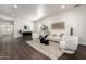 Living room with dark wood floors, white walls, a white couch, and two accent chairs at 41375 N Salix Dr, San Tan Valley, AZ 85140