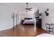 Main bedroom with hardwood floors, large TV, and ceiling fan at 3925 W Charter Oak Rd, Phoenix, AZ 85029