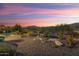 Backyard with gravel landscaping, desert plants, and sunset view at 4934 N 210Th Ave, Buckeye, AZ 85396