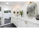 Contemporary bathroom with double vanity, white cabinets, and a door leading to the backyard at 7730 N 2Nd Ave, Phoenix, AZ 85021