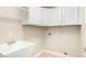 Laundry room with white cabinets and utility sink at 8351 W Taro Ln, Peoria, AZ 85382