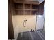 Open laundry closet with upper cabinets and hookups at 9427 E University Dr # 46, Mesa, AZ 85207