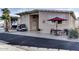 Tan home exterior with covered patio, golf cart, and red umbrella on patio table at 17200 W Bell Rd # 1218, Surprise, AZ 85374
