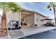 Tan home exterior with covered patio, golf cart, and palm trees at 17200 W Bell Rd # 1218, Surprise, AZ 85374