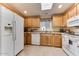 Kitchen features ample wood cabinets, modern appliances, and a skylight at 17200 W Bell Rd # 1218, Surprise, AZ 85374