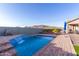 Inviting backyard pool with waterfall feature and brick patio at 18668 W Chuckwalla Canyon Rd, Goodyear, AZ 85338