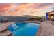 Inviting backyard oasis featuring a sparkling pool and waterfall, perfect for relaxation at 18668 W Chuckwalla Canyon Rd, Goodyear, AZ 85338