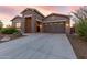 Modern home exterior with stone accents and a three-car garage at 18668 W Chuckwalla Canyon Rd, Goodyear, AZ 85338