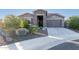 Attractive home exterior with stone accents and a landscaped front yard at 18668 W Chuckwalla Canyon Rd, Goodyear, AZ 85338