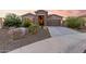 Beautiful home exterior featuring a stone facade and a spacious driveway at 18668 W Chuckwalla Canyon Rd, Goodyear, AZ 85338