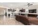 Open living space with a modern kitchen and a large TV at 18668 W Chuckwalla Canyon Rd, Goodyear, AZ 85338