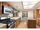 Kitchen with wood cabinets, gas range, and access to dining area at 2716 E Voltaire Ave, Phoenix, AZ 85032