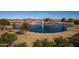 Aerial view of a community lake with fountain, landscaping, and walking paths at 297 W Seaside Dr, Casa Grande, AZ 85122