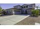 Two-story house with gray siding, a three-car garage, and a large driveway at 297 W Seaside Dr, Casa Grande, AZ 85122