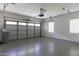 Spacious garage with overhead door, epoxy floor, and storage hooks at 297 W Seaside Dr, Casa Grande, AZ 85122