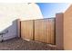 Wooden gate with black metal frame providing backyard access at 5203 W Roundhouse Rd, Laveen, AZ 85339