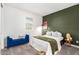 Bedroom with a bed, blue bench, and a green accent wall at 5203 W Roundhouse Rd, Laveen, AZ 85339